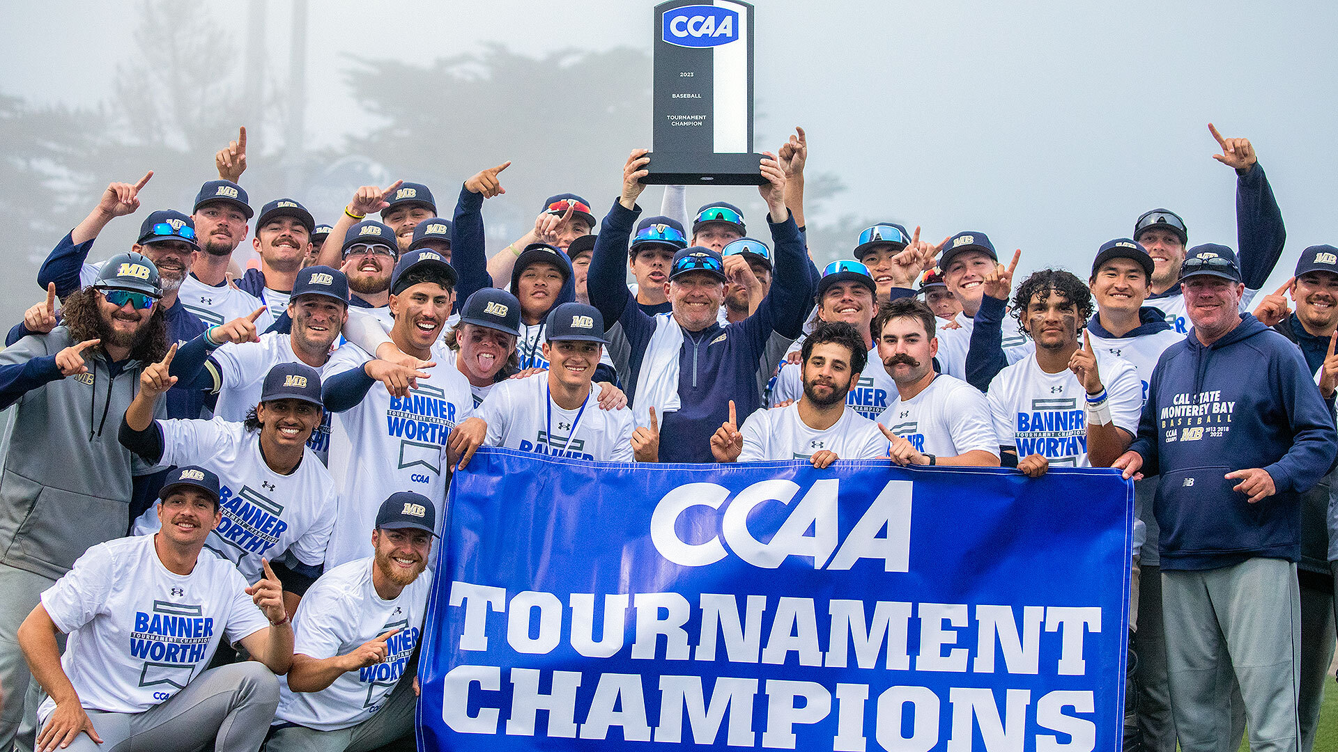 CSUMB Baseball Team holding the CCAA Tournament Championship trophy and banner