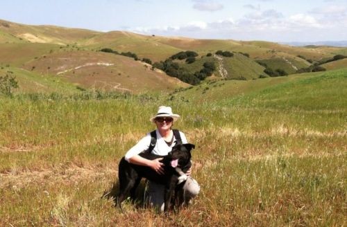 Dr. L. Maki Haffa in a field with Tillie.