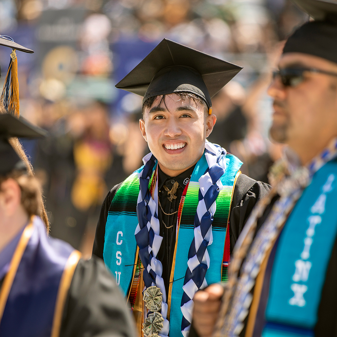 Photo: Class of 2022 Latinx graduate smiling in a crowd