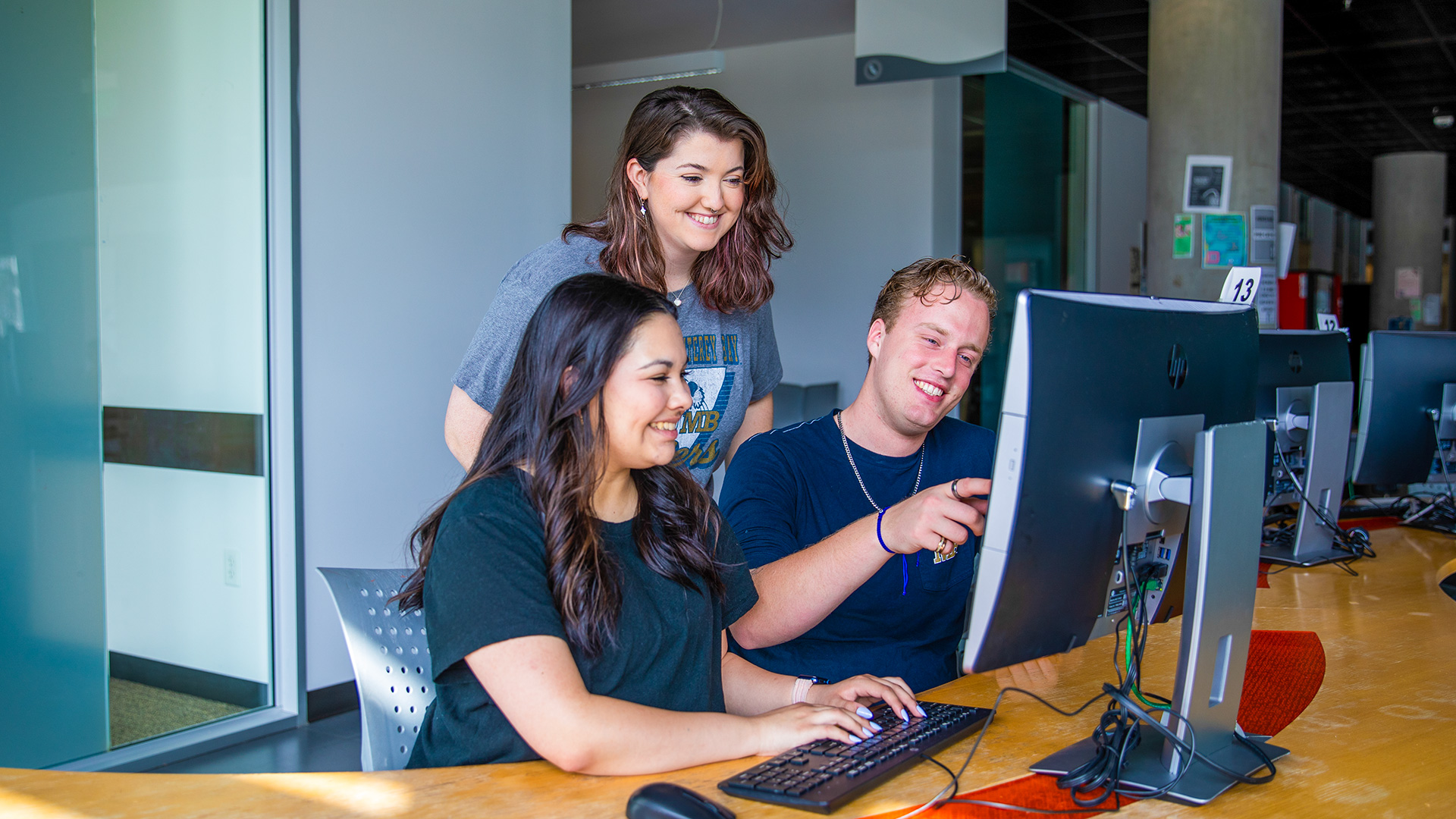 Three students using the computer at the library