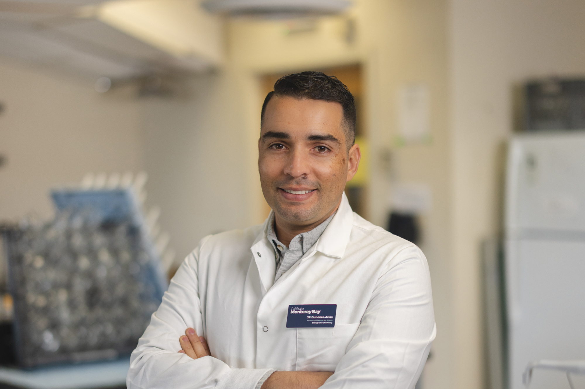 Professor smiling for a portrait in a labcoat.