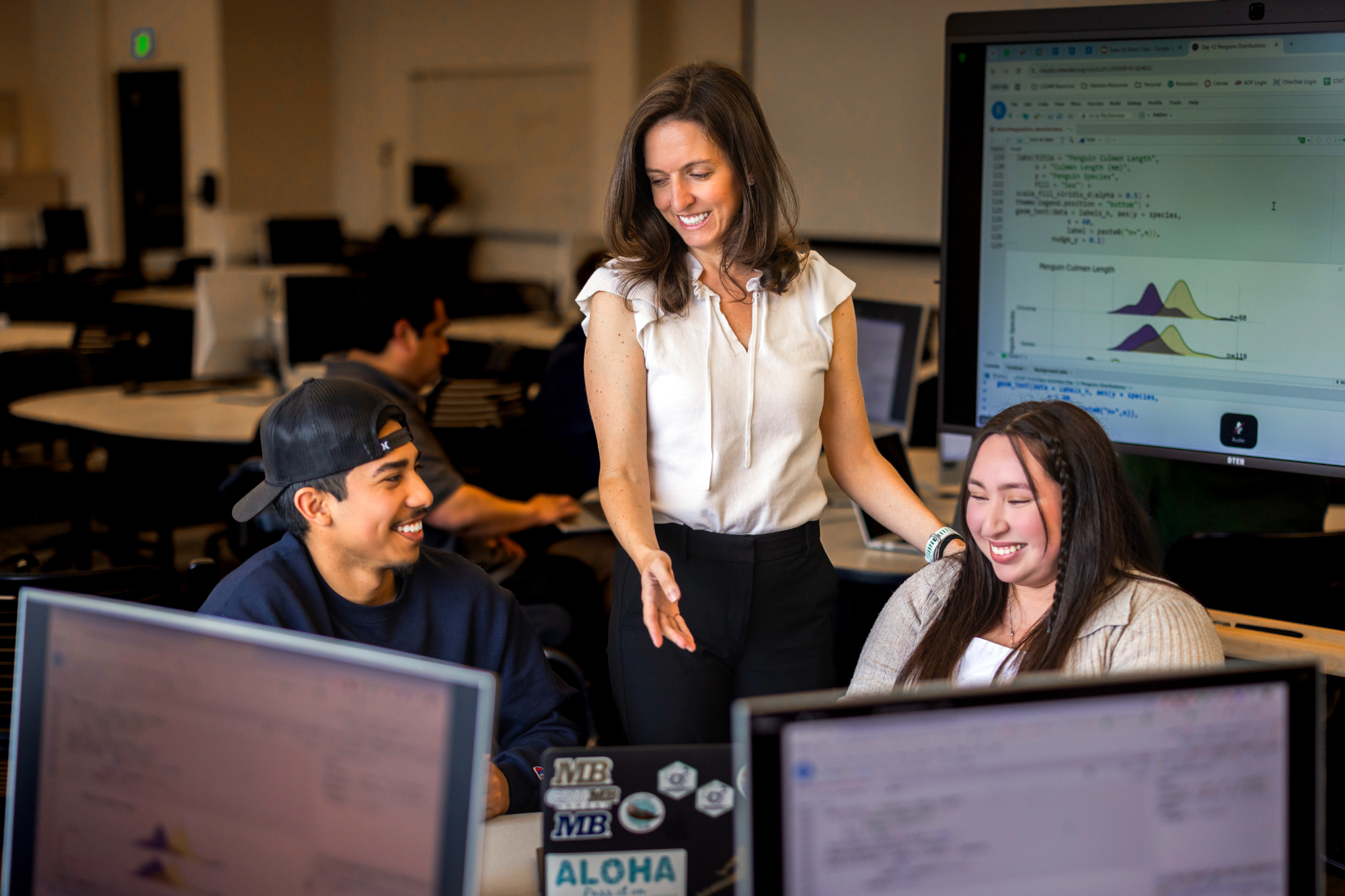 Dr. U assisting two students with statistics in a classroom setting