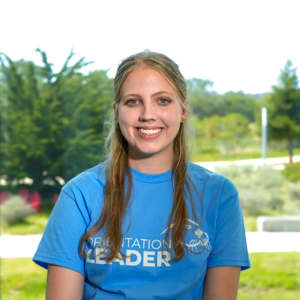 Portrait of an orientation leader standing outdoors on campus.