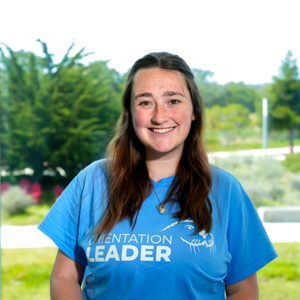 Portrait of an orientation leader standing outdoors on campus.