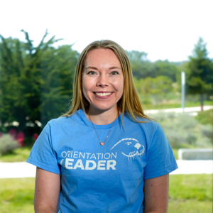 Portrait of an orientation leader standing outdoors on campus.
