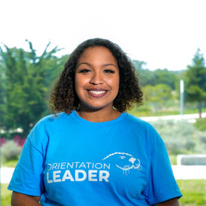 Portrait of an orientation leader standing outdoors on campus.