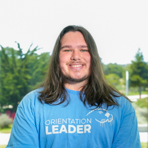 Portrait of an orientation leader standing outdoors on campus.