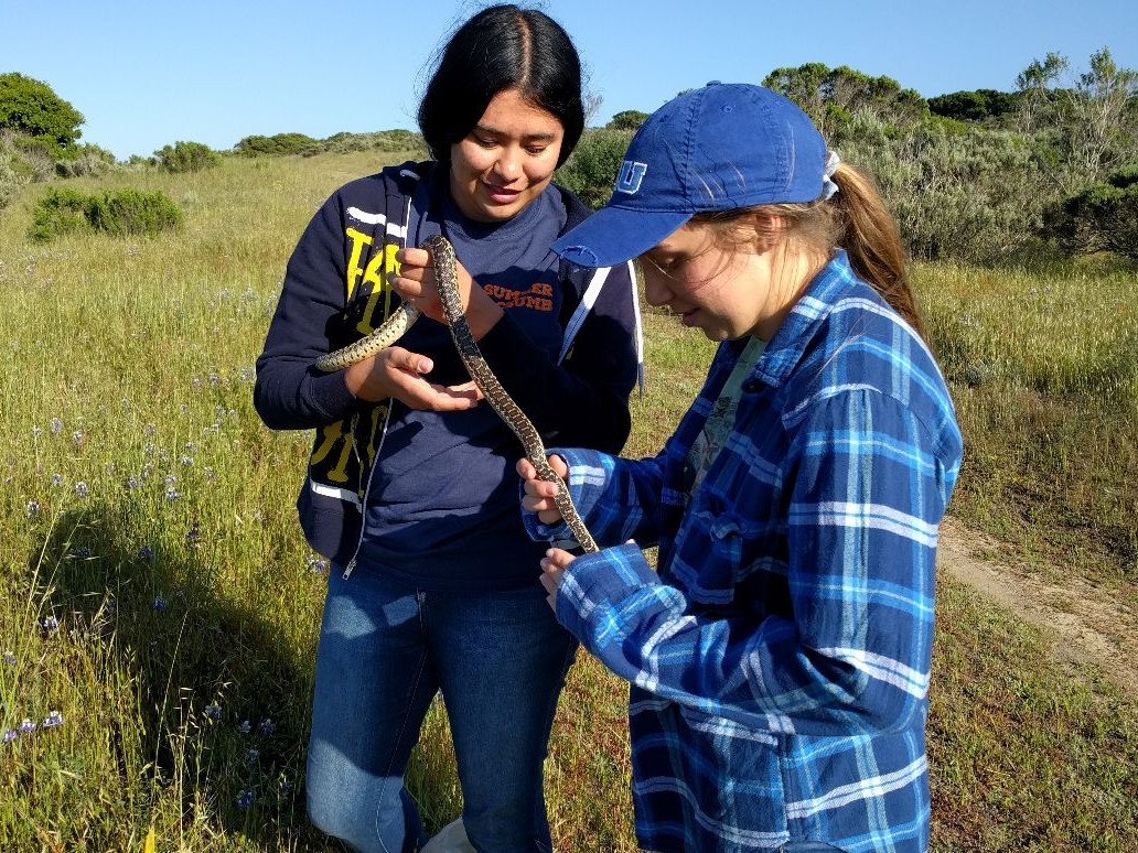 Image of Samantha Gautreaux and Bridget Rittmann holding a snake