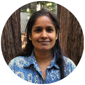 Image of Anjali Misra smiling wearing a blue floral print shirt