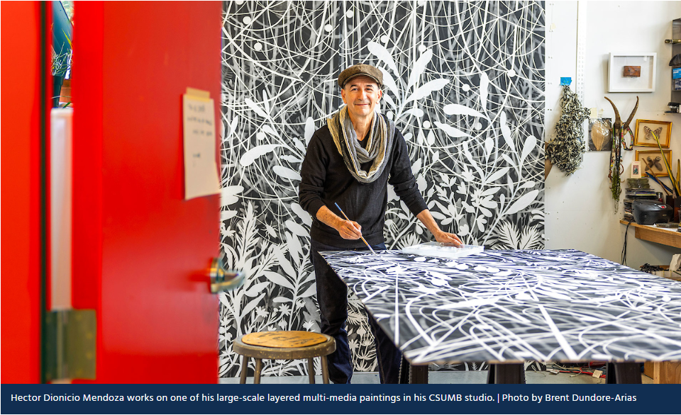 PVA faculty Dio Mendoza stands with his art