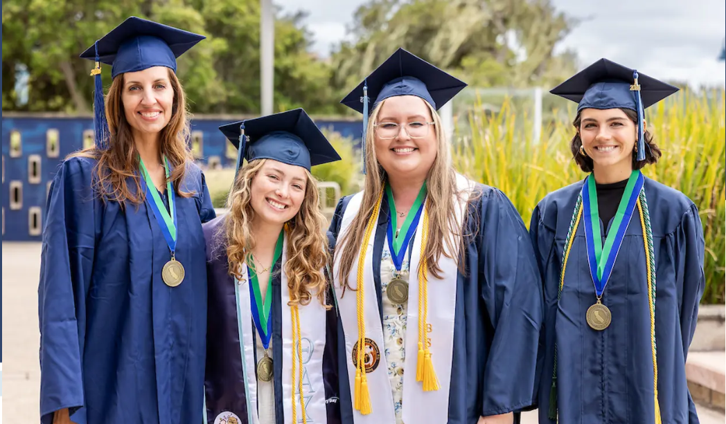 four graduates standing together