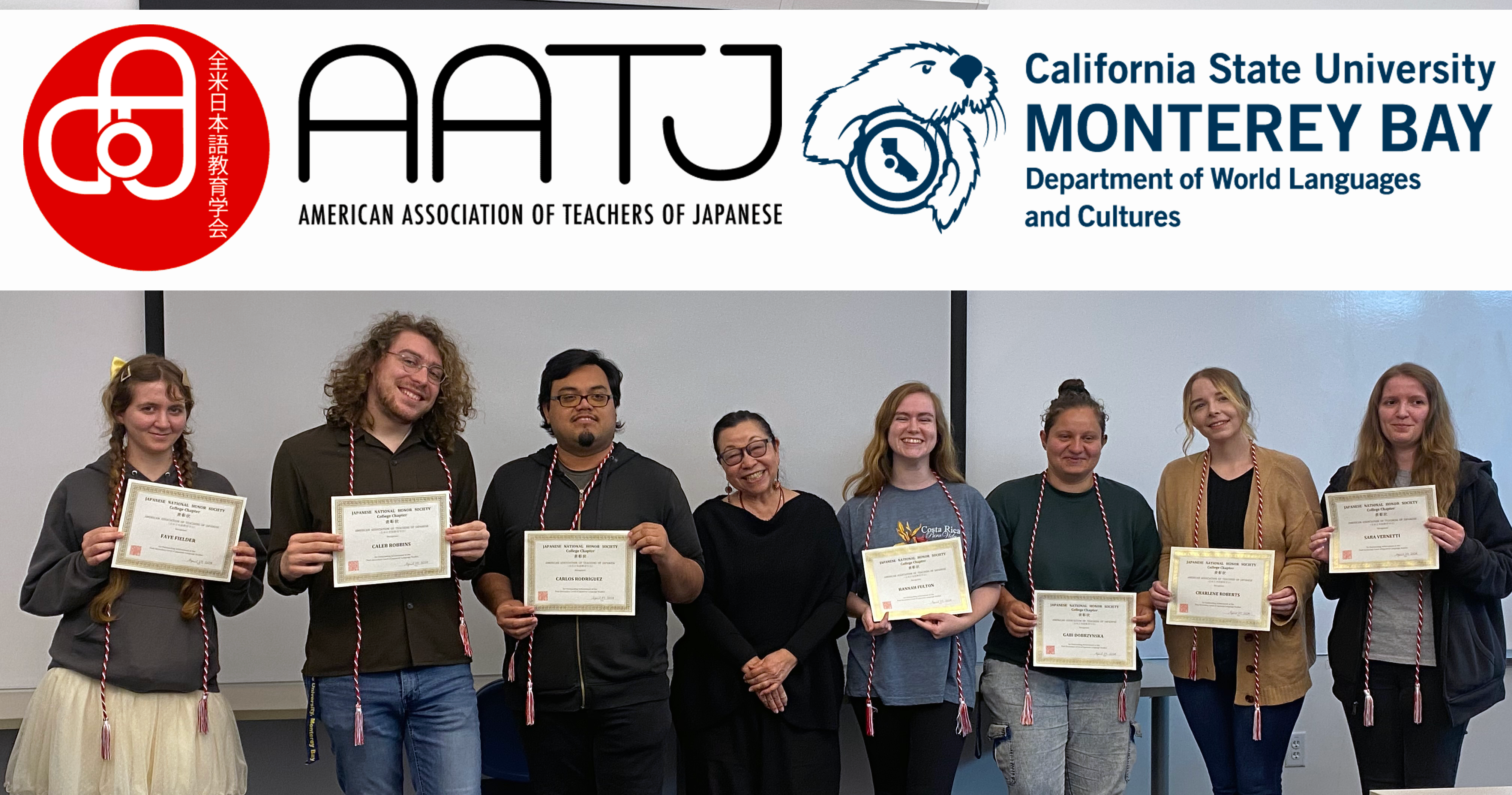 Seven students holding certificates of induction to Japanese Honor Society posing with instructor