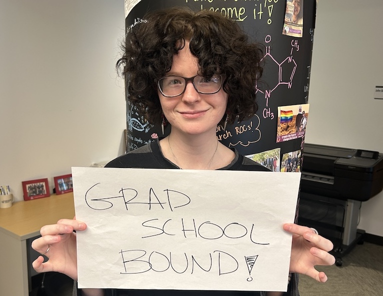 Student holding sign saying Grad School Bound