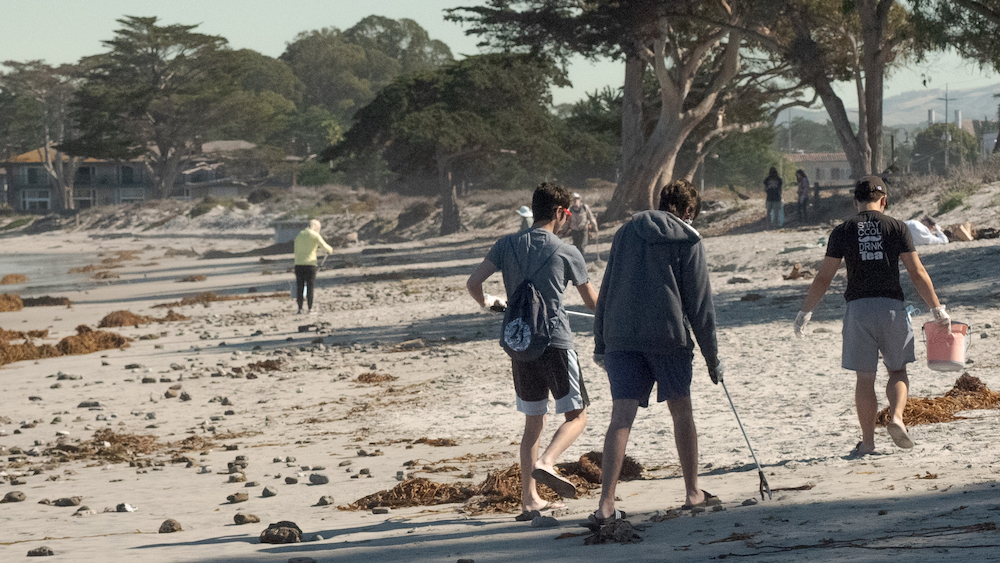 Students picking up trash on the beach.