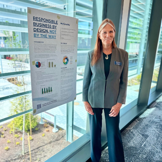 Kelly O'Brien standing next to poster.