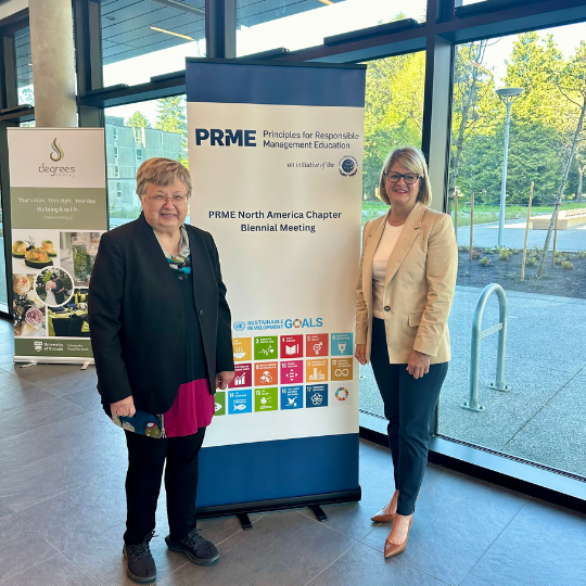 Marylou Shockley and Paige Viren next to poster.