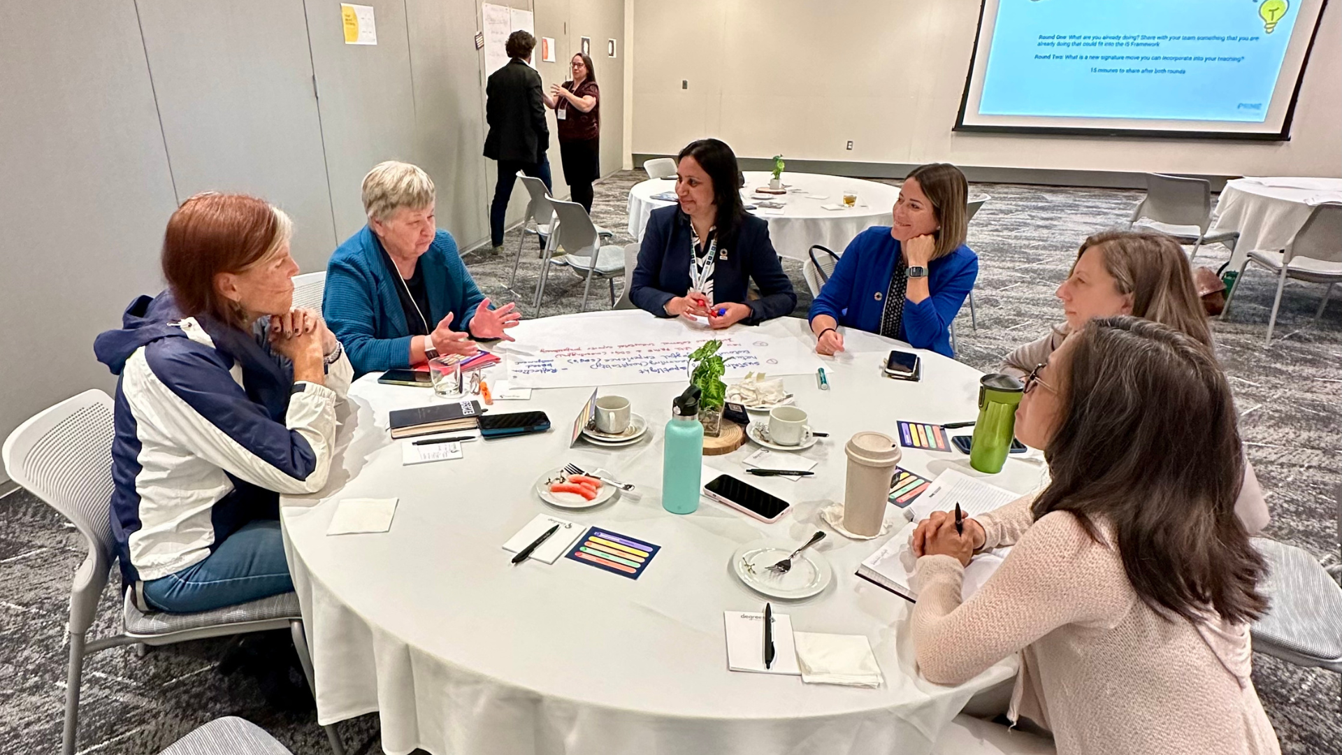 Marylou Shockley and Kelly O'Brien and others conversing at a table.