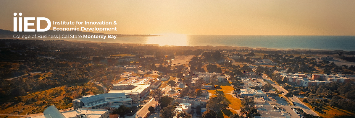 A scenic view of the CSUMB campus featuring the iconic clock tower, with the Institute for Innovation and Economic Development (iiED) logo overlaid.