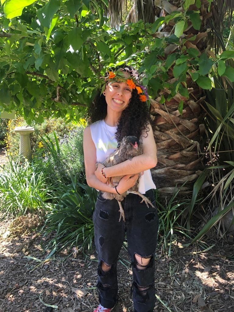 Kianni holding a chicken an wearing a flower crown