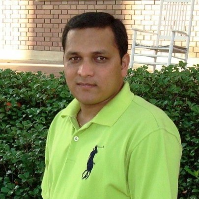 Dhan Khadka headshot in front of a hedge