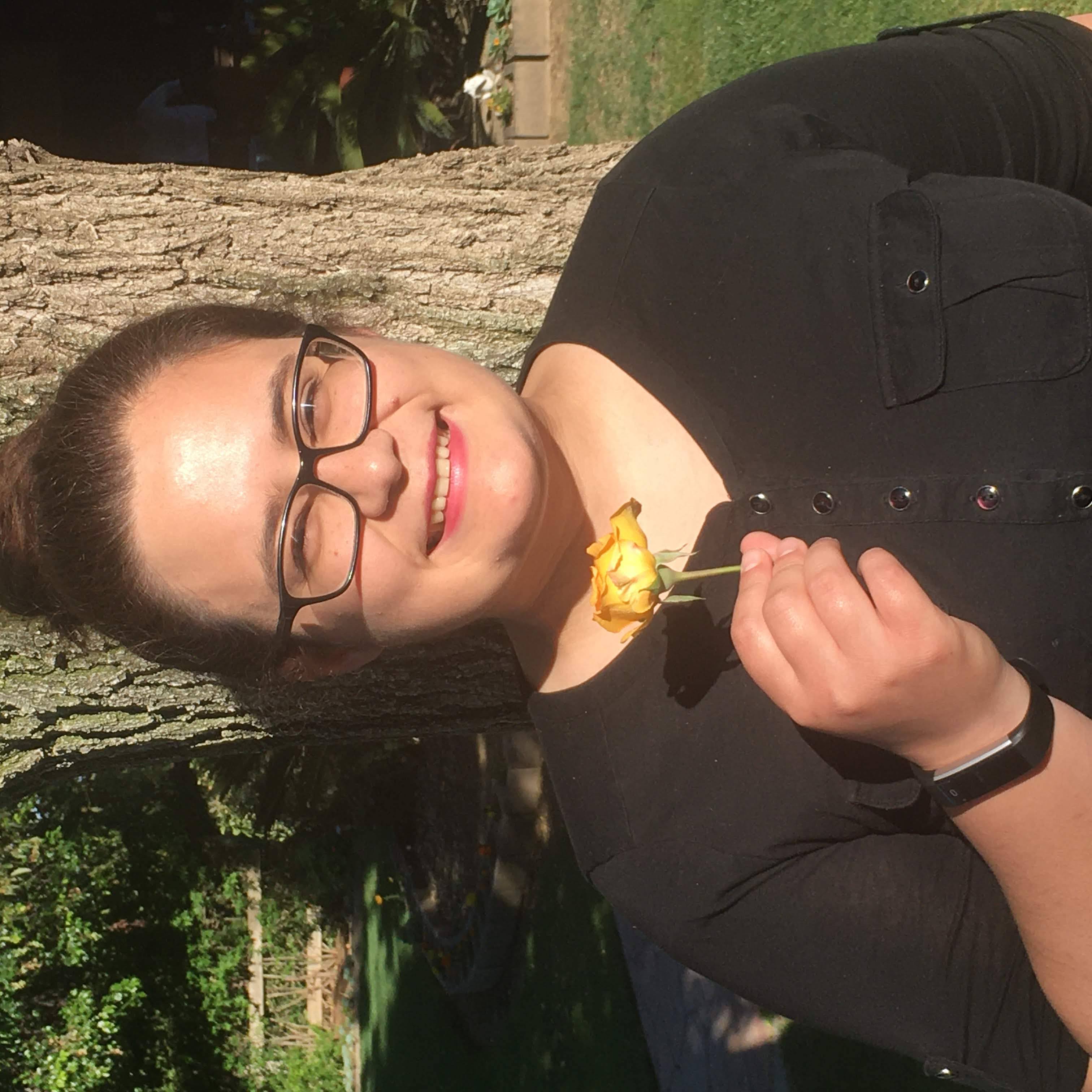 Headshot image of Kierra Rambonga holding a yellow rose