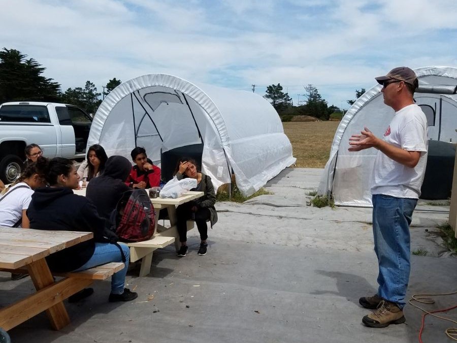 Students listen to an outdoor lecture