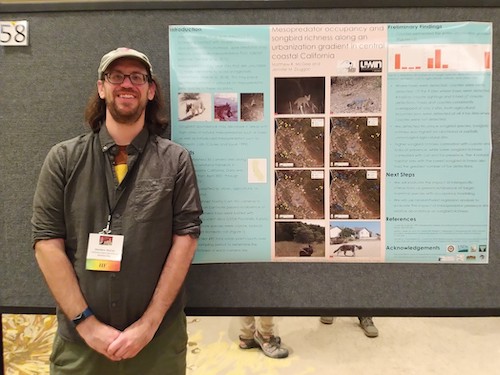 Matthew McGee poses with his poster at a conference