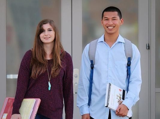 CSUMB students pose with backpacks and books