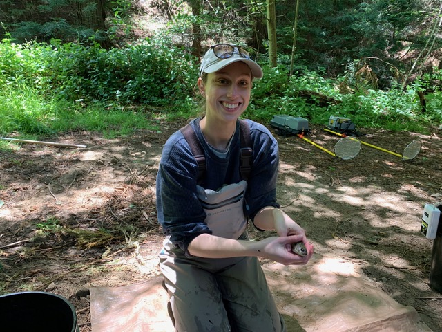 Sarah smiling and holding a fish in her hands