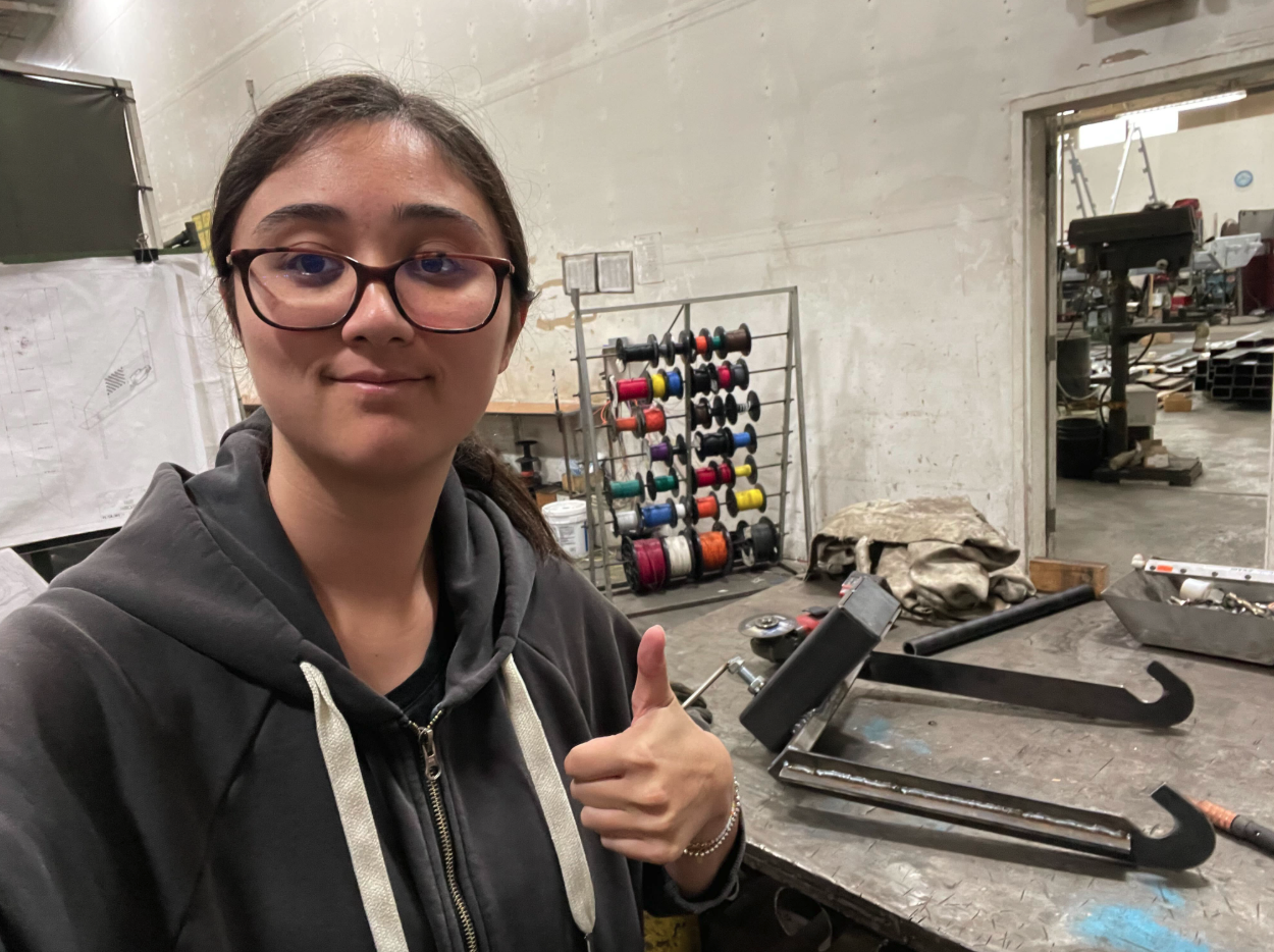Student at internship site, showing welding piece
