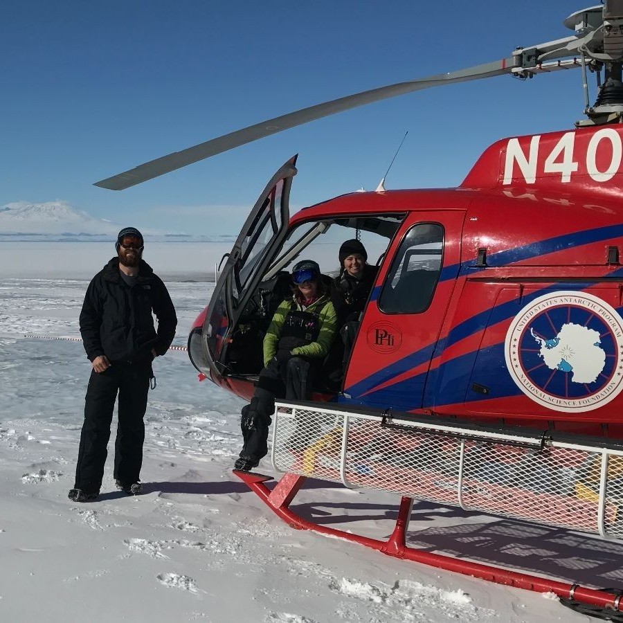 ESTP alumni next to hellicopter