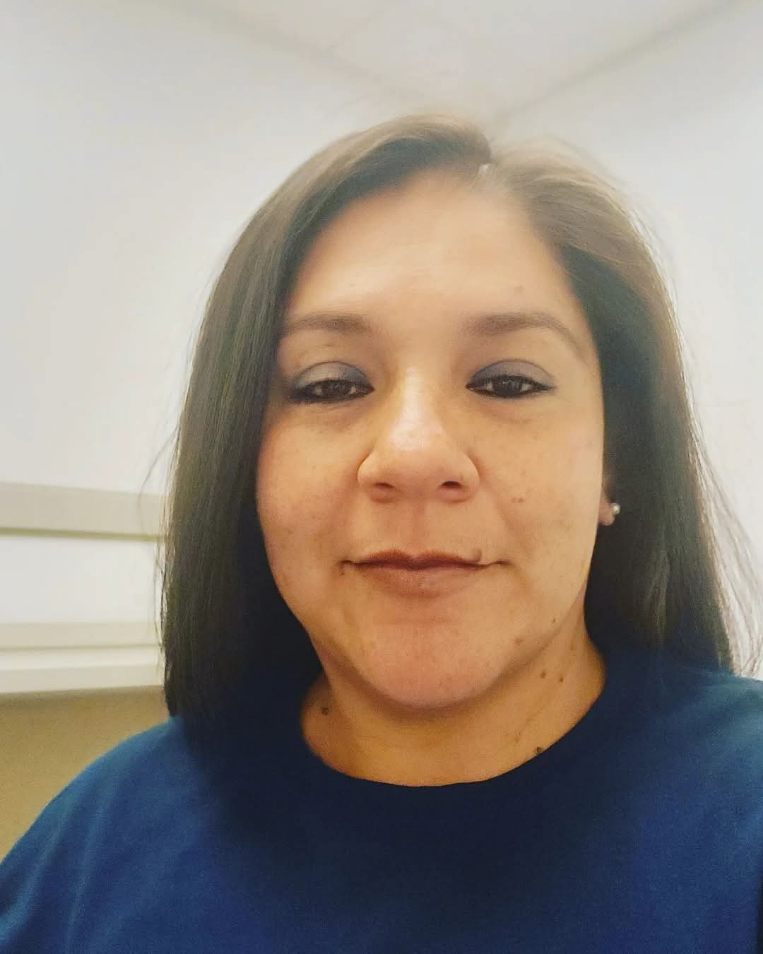 Woman with dark hair smiling at the camera