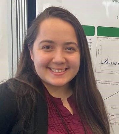 Woman in front of a white board smiling at the camera