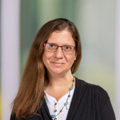 A Woman with glasses smiling at the camera