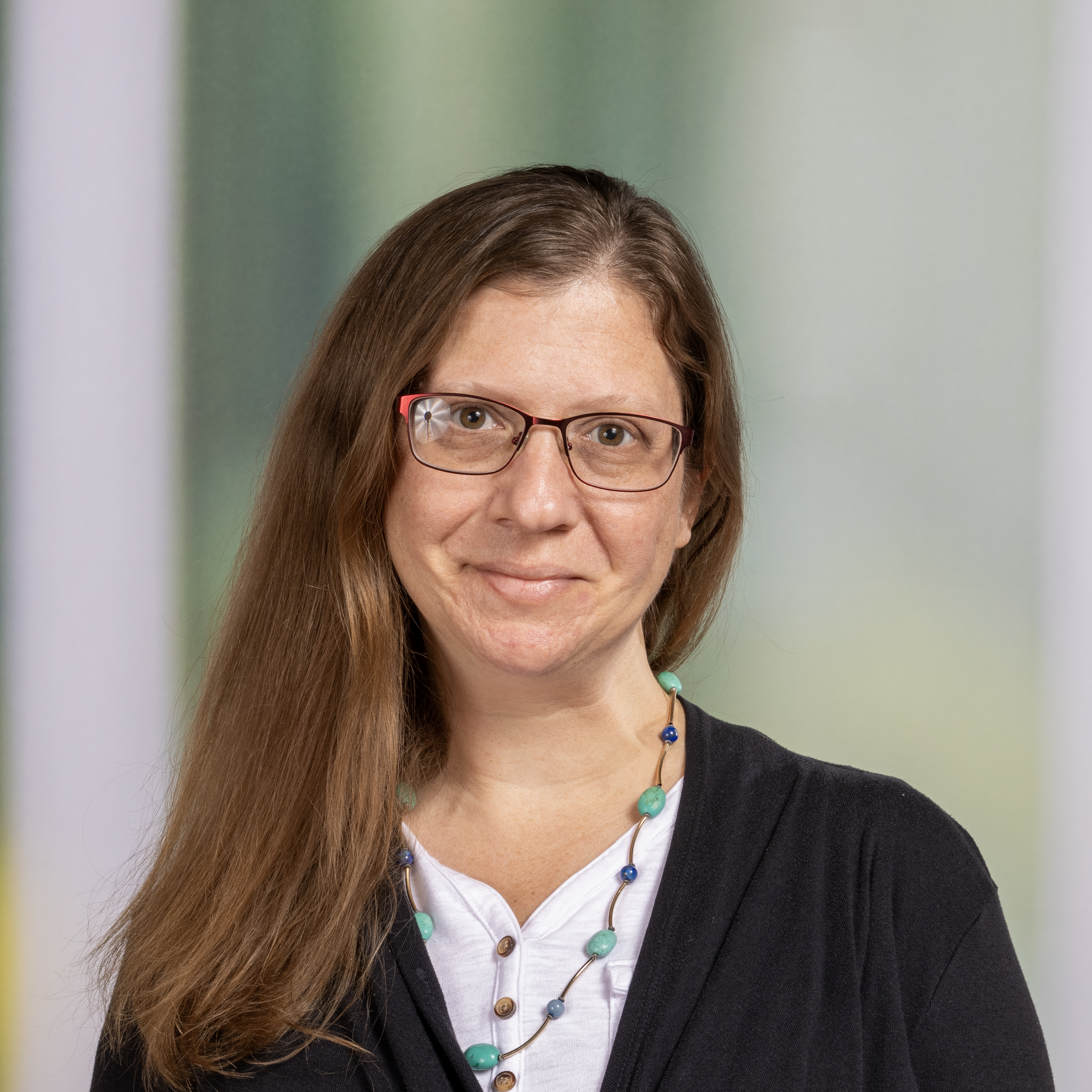 A Woman with glasses smiling at the camera