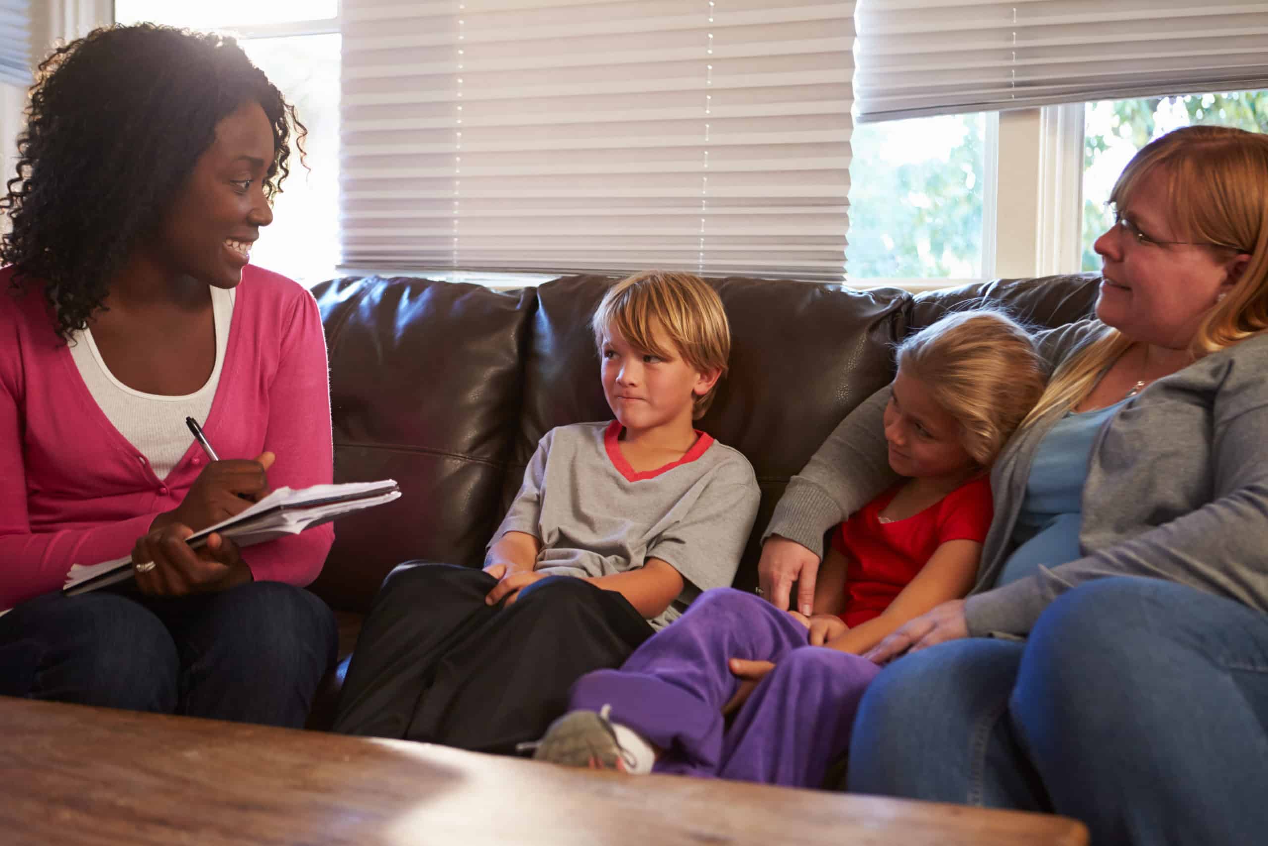 social worker talking with two children and a mother