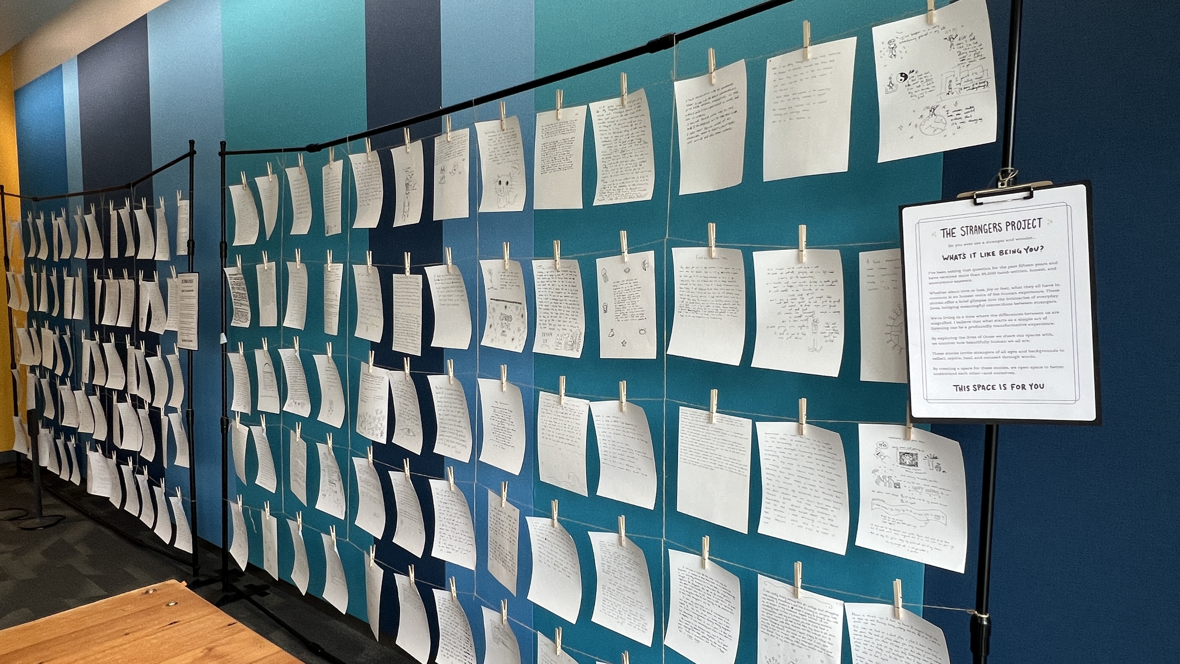 Photo of one of the three Strangers Project installations in the Otter Student Union featuring a wall of pinned open and anonymous letters