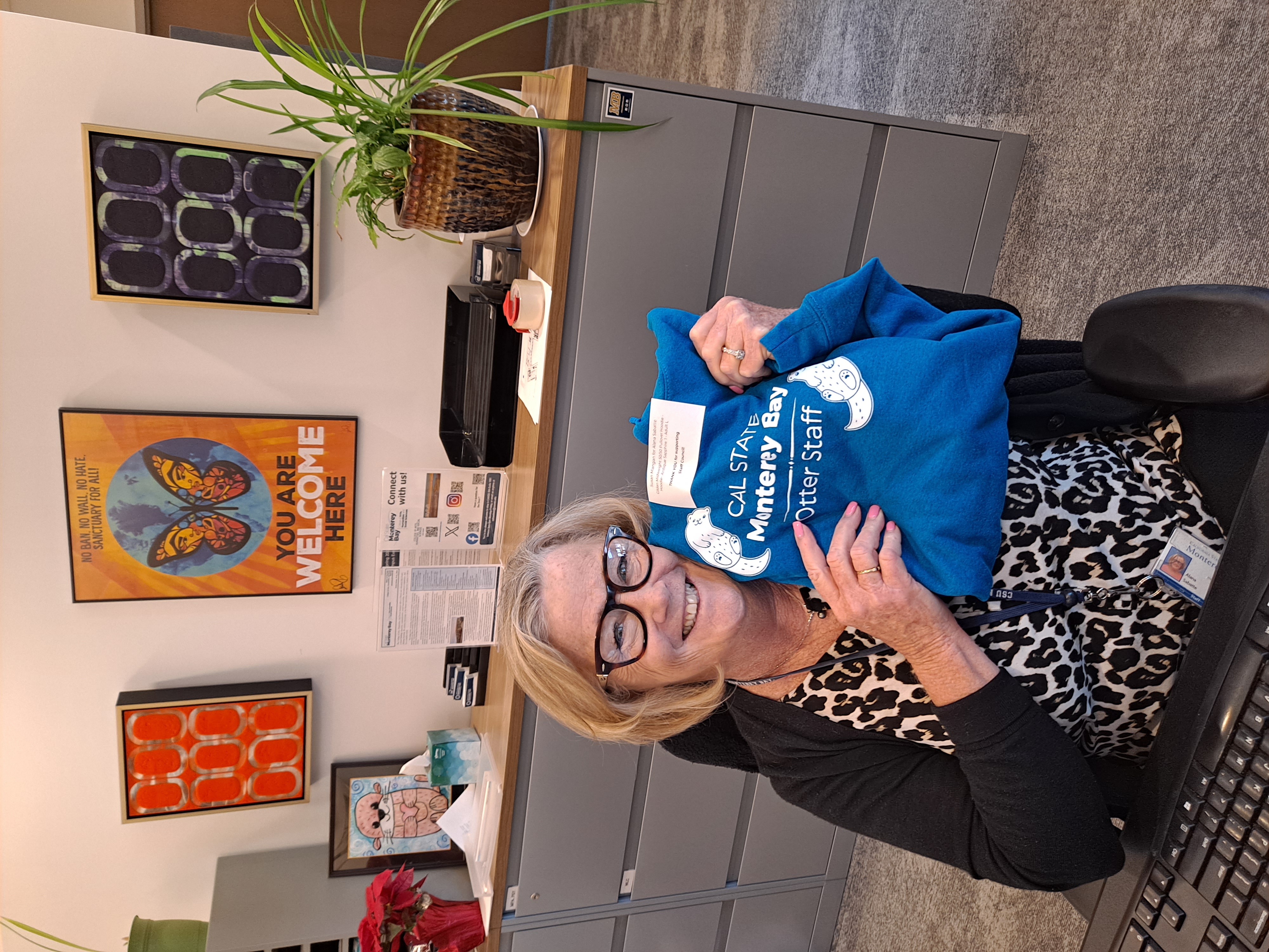 Alana Sabatte poses with a sweatshirt of her own otter design