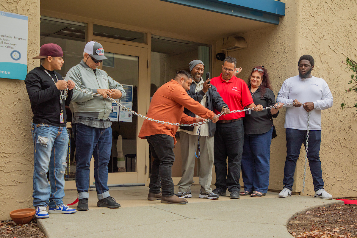 Oct 2024 CSUMB Project Rebound grand opening, ribbon cutting ceremony. People are gathered together to cut the ribbon in front of Project Rebound's Office