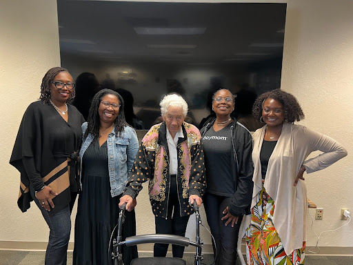 Five women standing in front of television inside of Helen Rucker Center