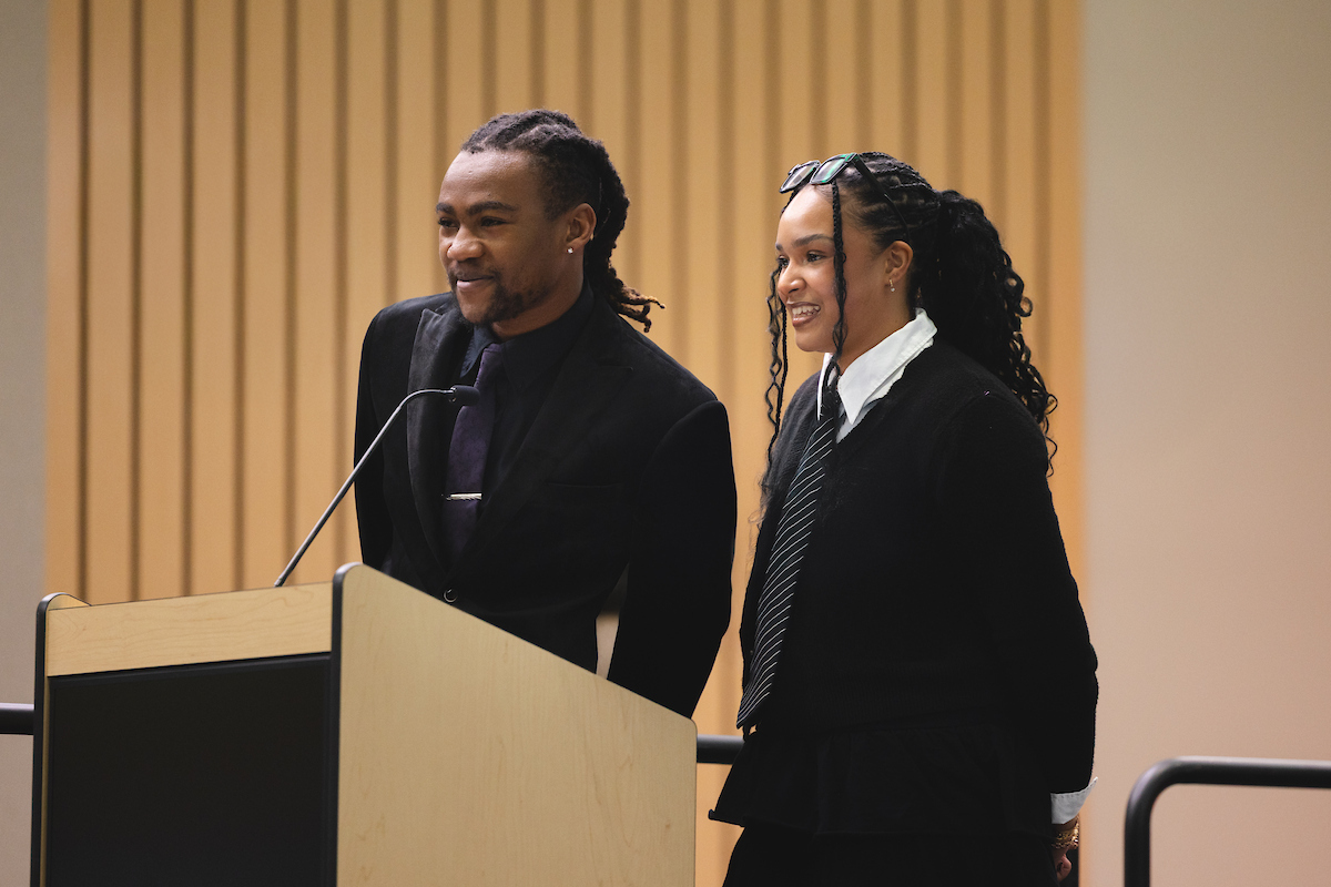 Two student speakers standing at podium at All Black Gala event