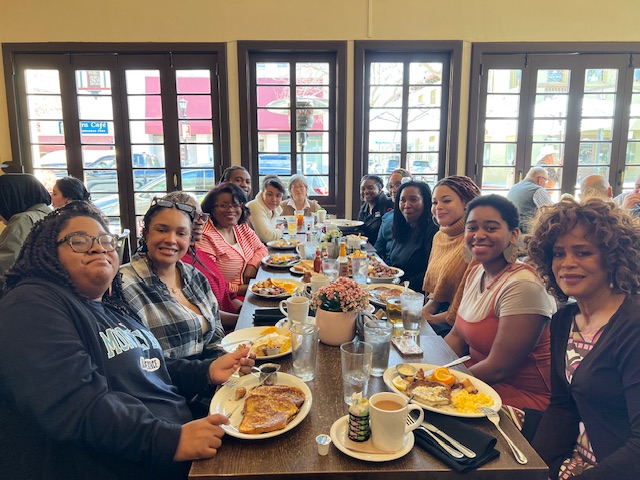 a group enjoying a meal at a large table inside of restaurant