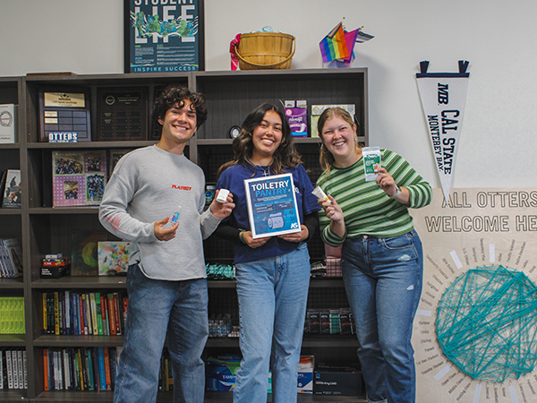 Three students visiting Associated Students Toiletry Pantry holding mini toiletry pantry items