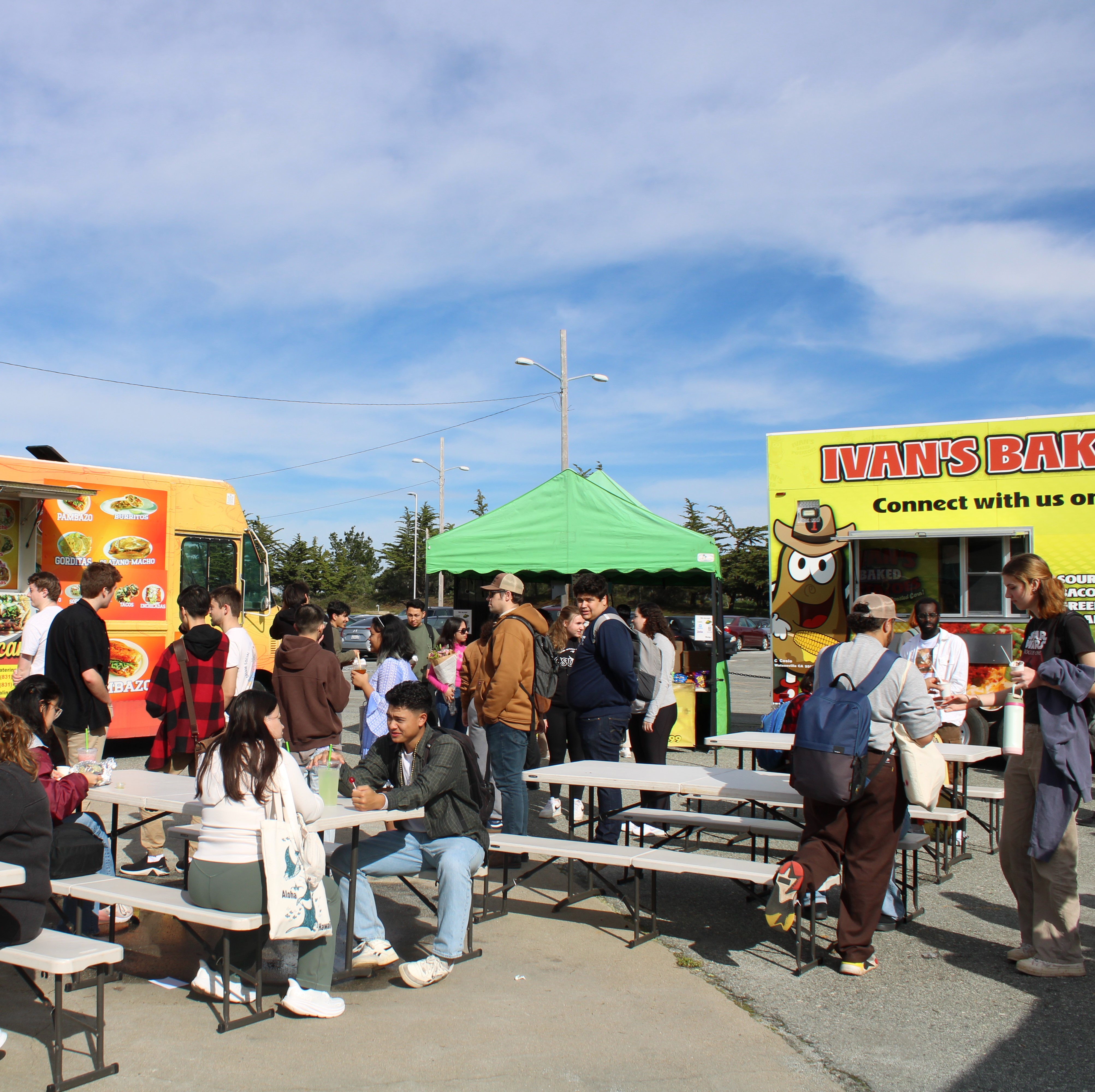 Many students sitting, talking, and shopping at the Farmers Market