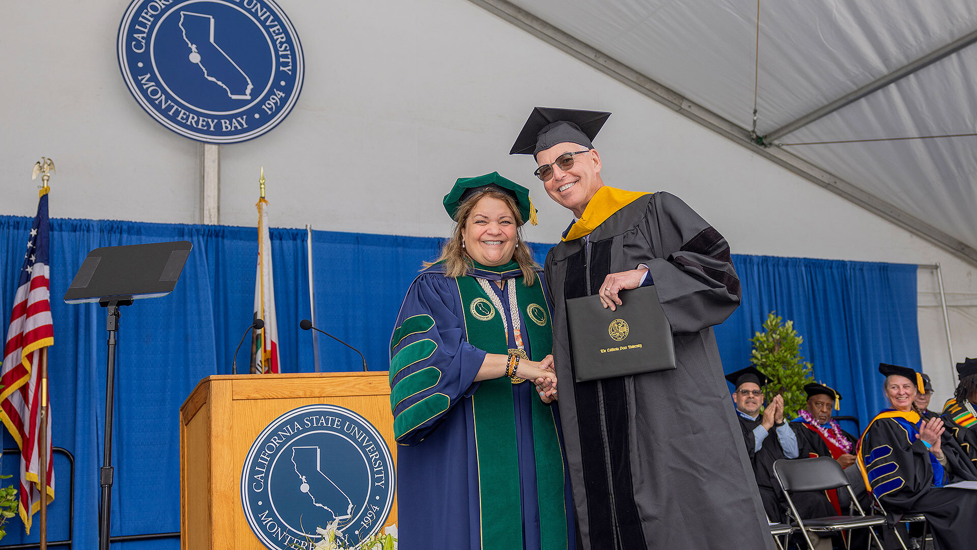 QuiƱones presenting Dr. Steven Packer with an honorary Doctor of Science degree