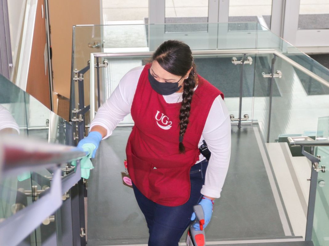 Woman disinfecting handrails