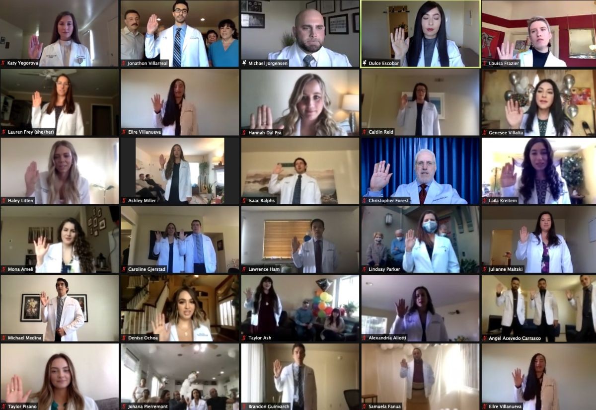 Physician assistant students raise their right hands while reciting an oath during the virtual White Coat Ceremony on Feb. 13.