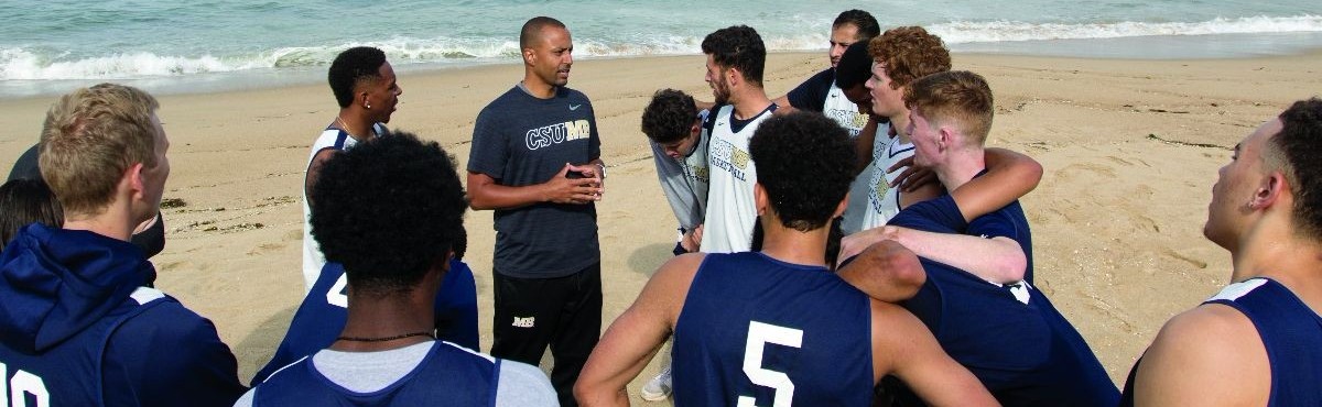 CSUMB men's basketball team huddles at the beach after a workout