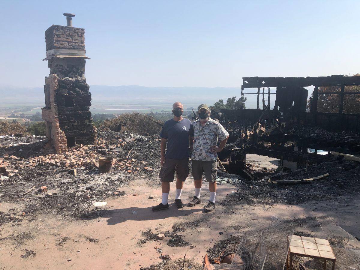 Chip Lenno (left) and Kevin Cahill stand where their front door used to be. Behind them, the former living room, office and kitchen with a view of the Salinas Valley.