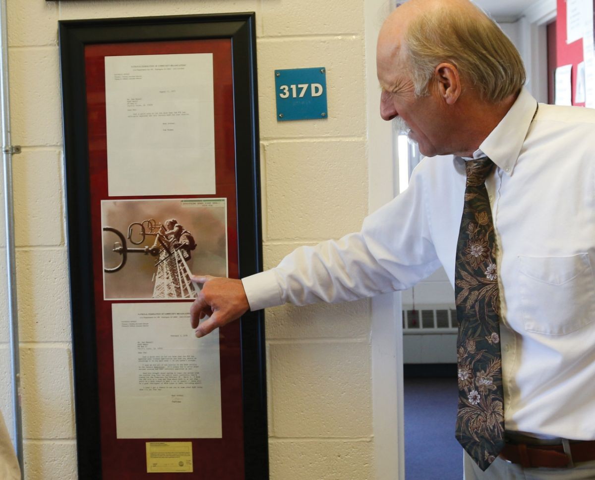 General manager Mik Benedek looks at a photo of station founder Don Mussell.